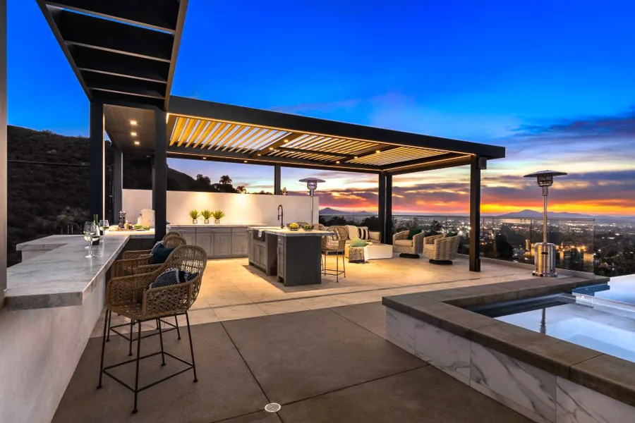 A stylish patio cover featuring comfortable seating, warm ambient lighting, and stunning sunset views.