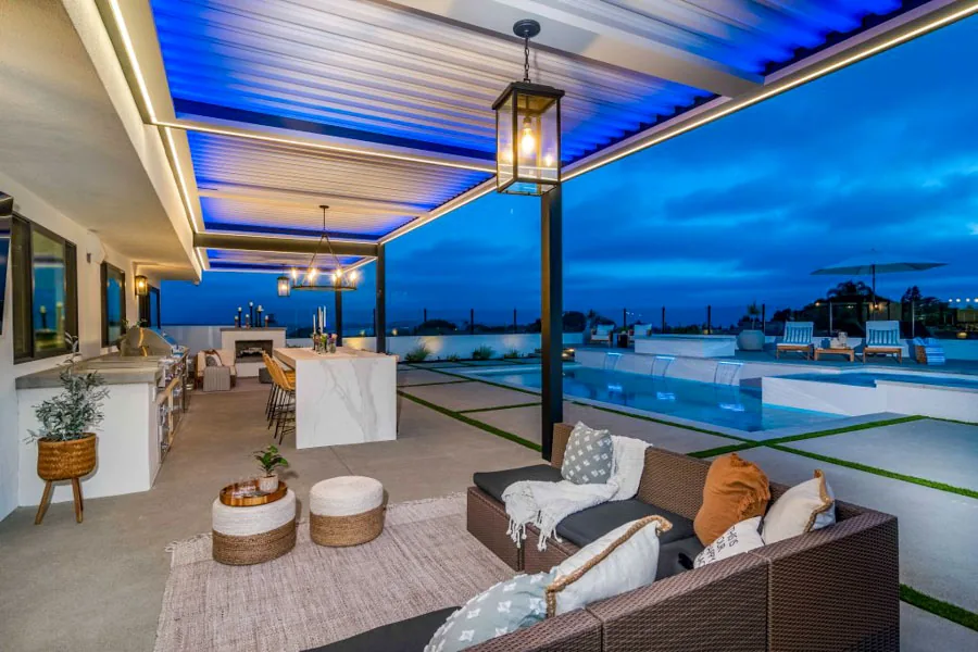 A stylish patio setup with comfortable seating, warm ambient lighting, and stunning sunset views.
